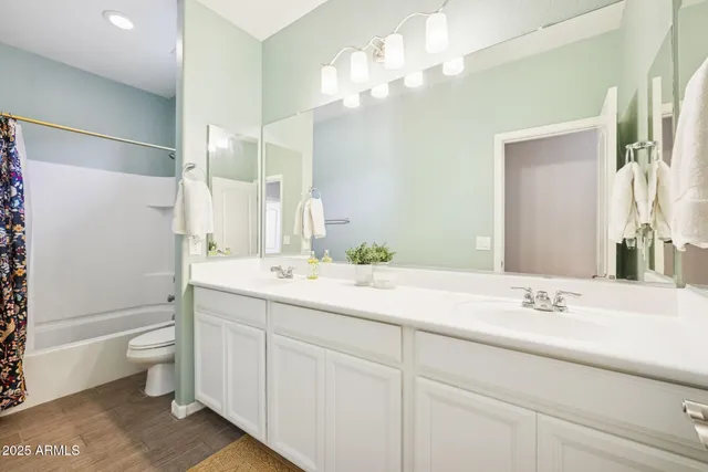 a bathroom with a double vanity sink toilet and shower