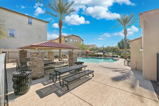 a patio with table and chairs and potted plants