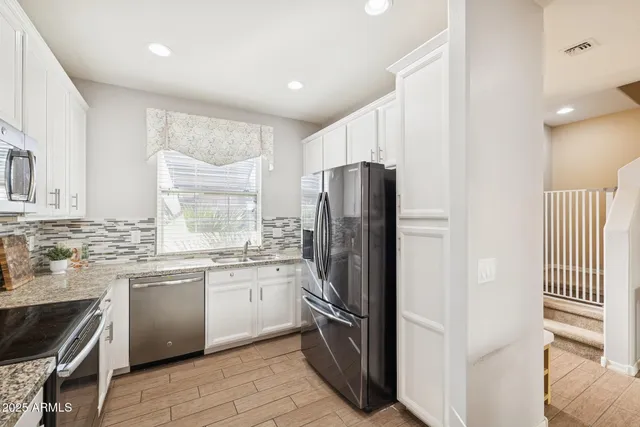 a kitchen with stainless steel appliances a refrigerator sink and stove