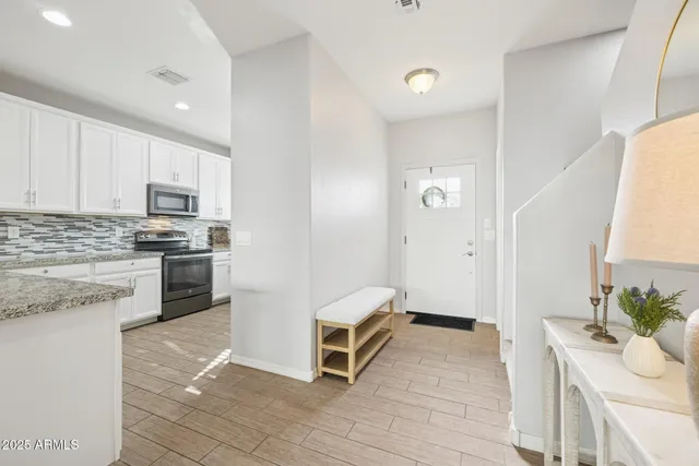 a kitchen with granite countertop white cabinets and stainless steel appliances