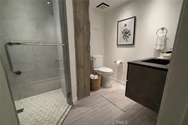 a bathroom with a sink a toilet and shower