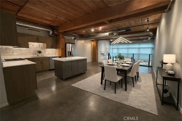 a dining room with furniture and view of kitchen