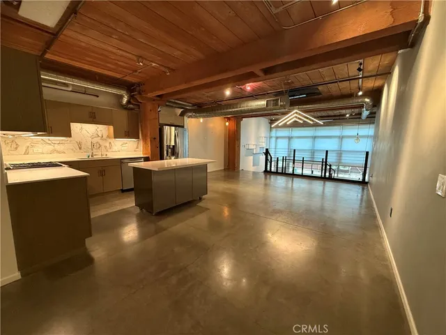 a view of a livingroom with furniture and a kitchen view