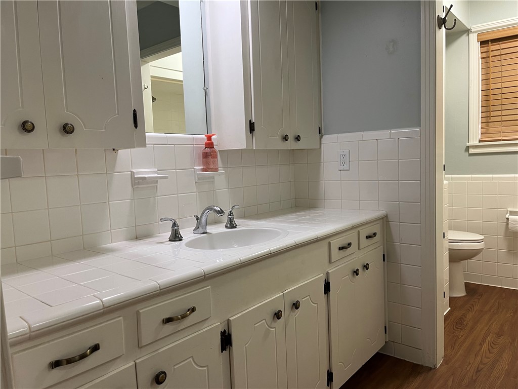 749 San Patricio Avenue Taft, TX 78390 - Photo 32 of 40 a bathroom with a granite countertop sink a toilet and a mirror