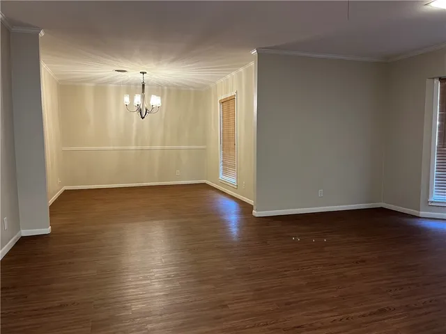 an empty room with wooden floor and door