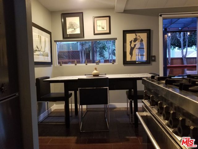 a room with granite countertop a sink and a stove with wooden floor