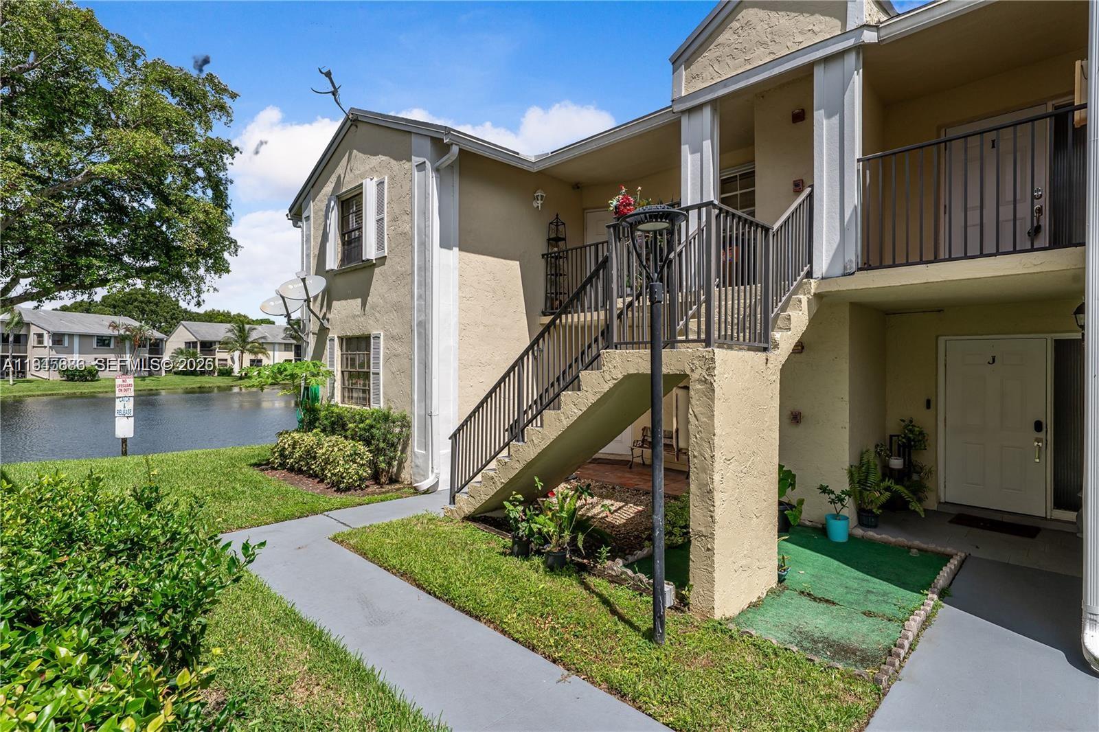 1031 Adams Avenue, Unit 1031I Homestead, FL 33034 - Photo 26 of 33 a front view of a house with a yard table and chairs