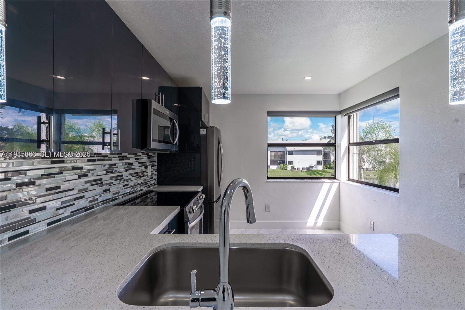 1031 Adams Avenue, Unit 1031I Homestead, FL 33034 - Photo 4 of 33 a kitchen with a sink and a refrigerator