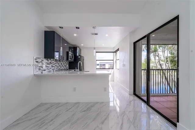 a view of kitchen with wooden floor and electronic appliances