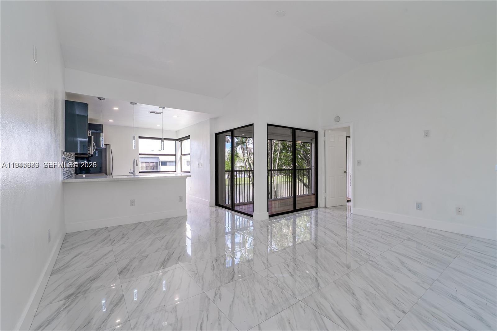1031 Adams Avenue, Unit 1031I Homestead, FL 33034 - Photo 6 of 33 wooden floor in an empty room with a window