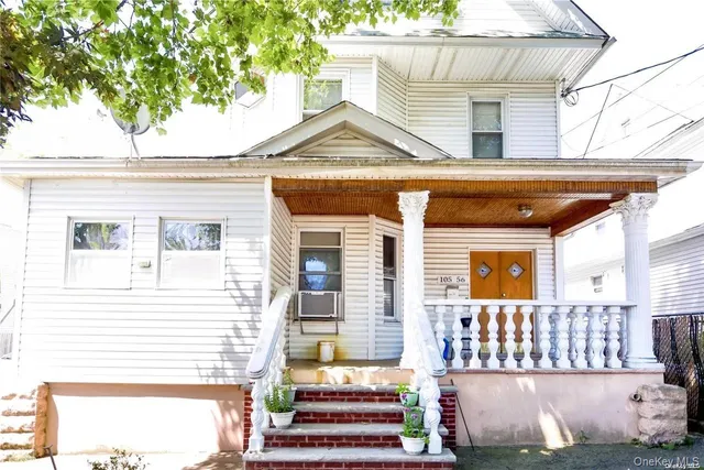 a view of a house with a small yard and wooden fence