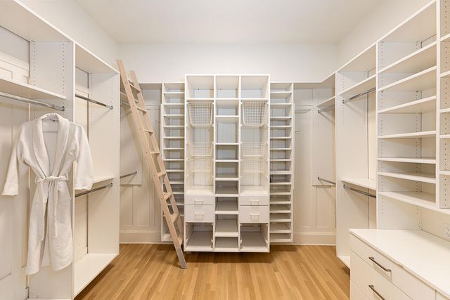 a view of walk in closet with wooden floor and entryway