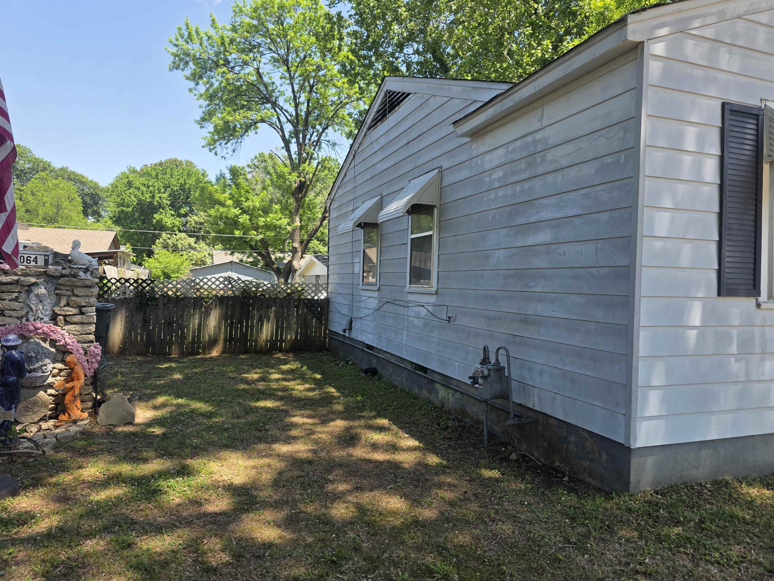 4072 Grey Road Memphis, TN 38108 - Photo 3 of 9 Side exterior of the property featuring horizontal siding and a fenced yard