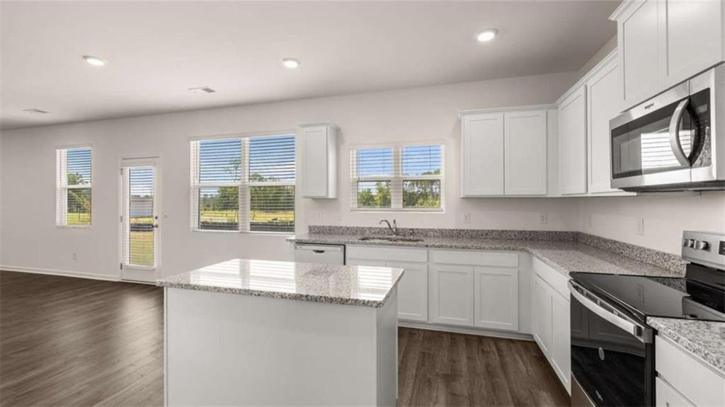 314 Friendship Oak Way Hampton, GA 30228 - Photo 3 of 32 a kitchen with stainless steel appliances granite countertop a sink stove and microwave