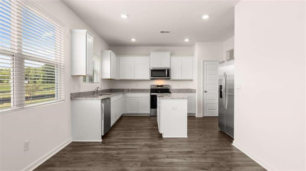 314 Friendship Oak Way Hampton, GA 30228 - Photo 4 of 32 a kitchen with white cabinets and appliances