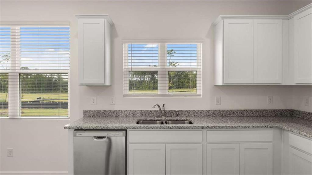 314 Friendship Oak Way Hampton, GA 30228 - Photo 7 of 32 a kitchen with stainless steel appliances granite countertop white cabinets and a window