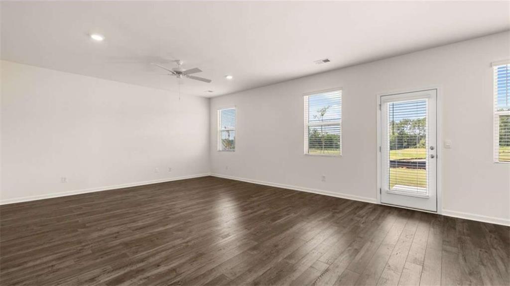 314 Friendship Oak Way Hampton, GA 30228 - Photo 10 of 32 an empty room with wooden floor chandelier fan and windows