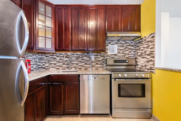 a kitchen with granite countertop cabinets and black stainless steel appliances