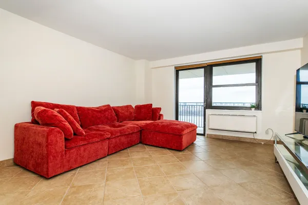 a living room with furniture and view of kitchen