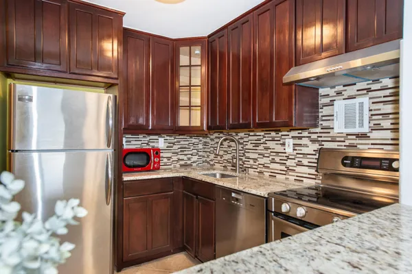 a kitchen with granite countertop a sink stove and cabinets