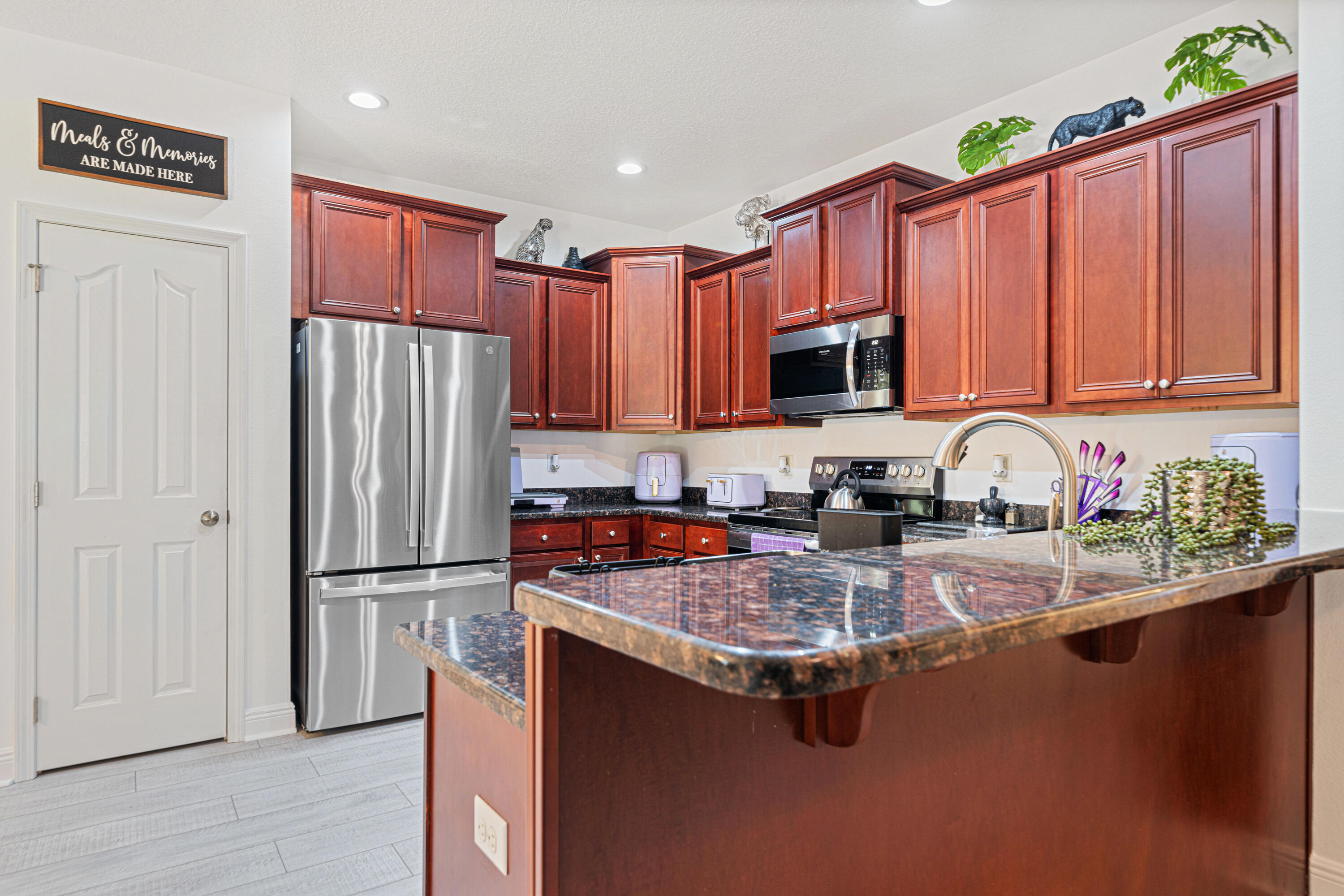 634 Red Fern Road Crestview, FL 32536 - Photo 6 of 21 a kitchen with granite countertop a refrigerator stove and microwave with wooden floor