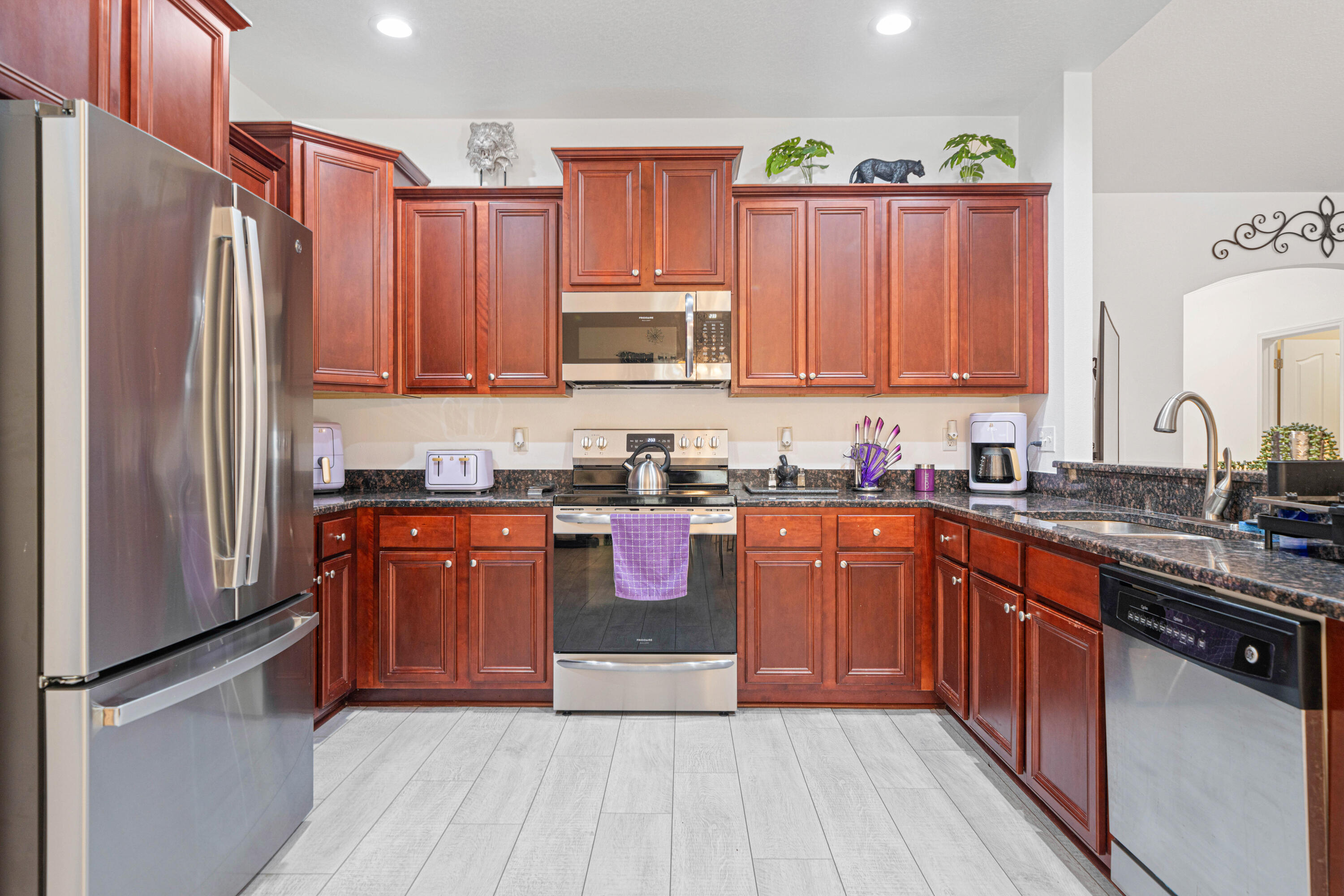 634 Red Fern Road Crestview, FL 32536 - Photo 7 of 21 a kitchen with stainless steel appliances granite countertop a refrigerator a sink dishwasher a stove with wooden cabinets and floor