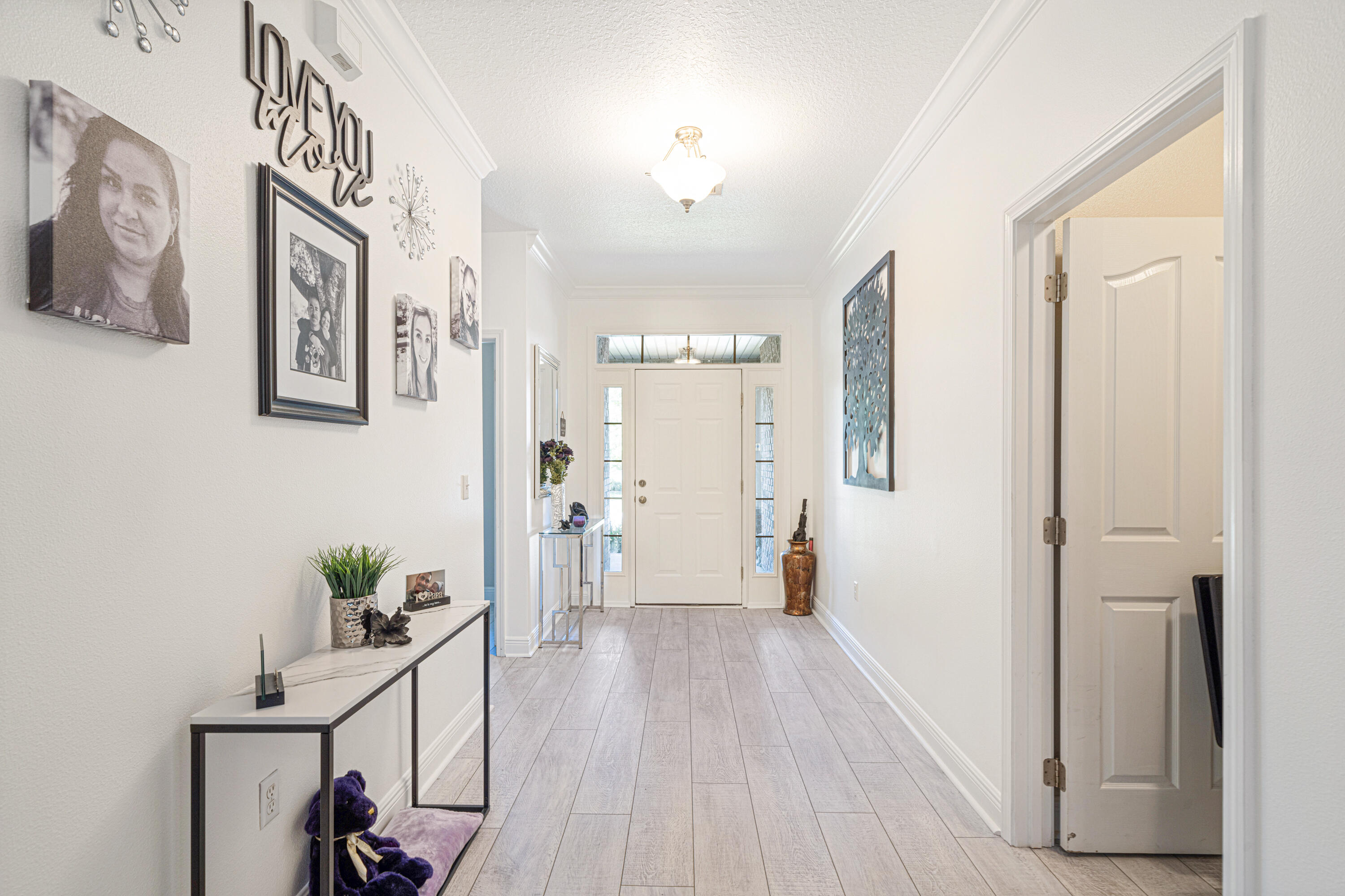 634 Red Fern Road Crestview, FL 32536 - Photo 9 of 21 a view of a hallway to a livingroom with wooden floor and furniture