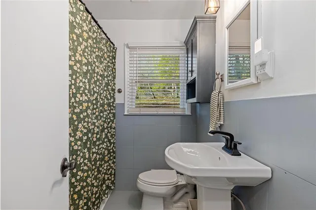 a bathroom with a sink a toilet and a mirror