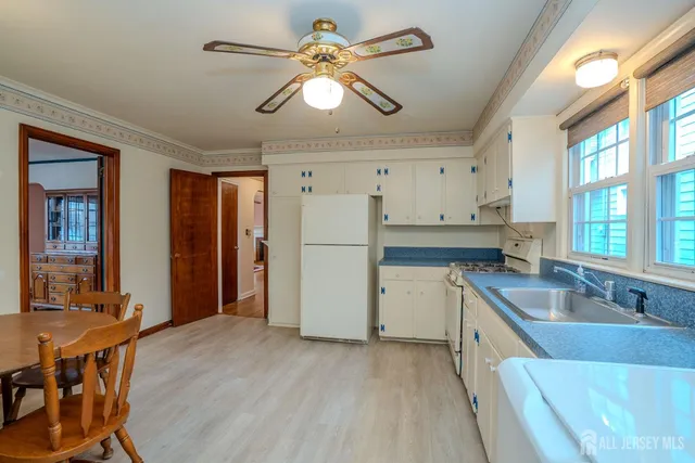 a kitchen with a refrigerator a sink and dishwasher with wooden floor