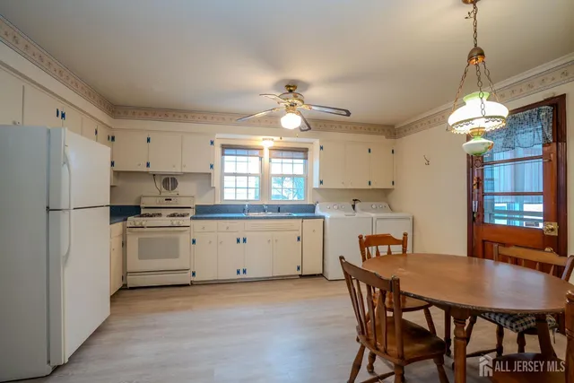 a kitchen with stainless steel appliances a dining table chairs stove and refrigerator