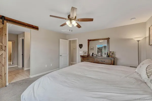 a bedroom with a large bed and chandelier