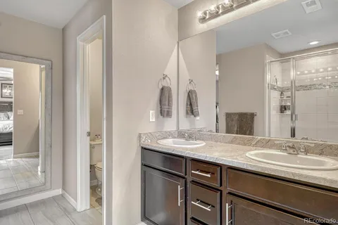a bathroom with a granite countertop sink a mirror and a shower