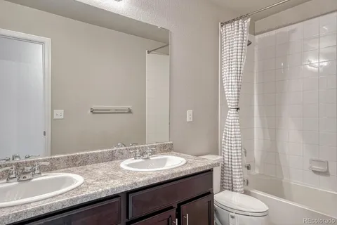 a bathroom with a granite countertop sink toilet a shower and a mirror