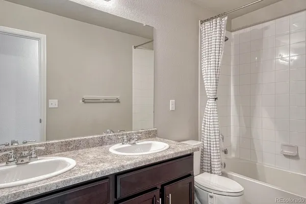 a bathroom with a granite countertop sink toilet a shower and a mirror