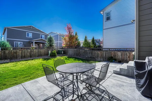 a view of a chair and table in backyard of the house