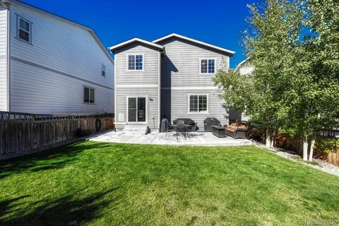 a view of a house with backyard and sitting area