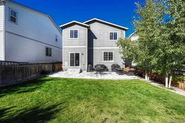 a view of a house with backyard and sitting area