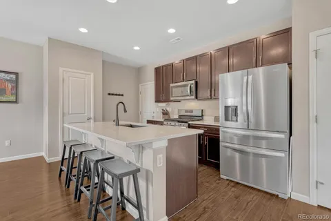 a kitchen with kitchen island white cabinets and stainless steel appliances