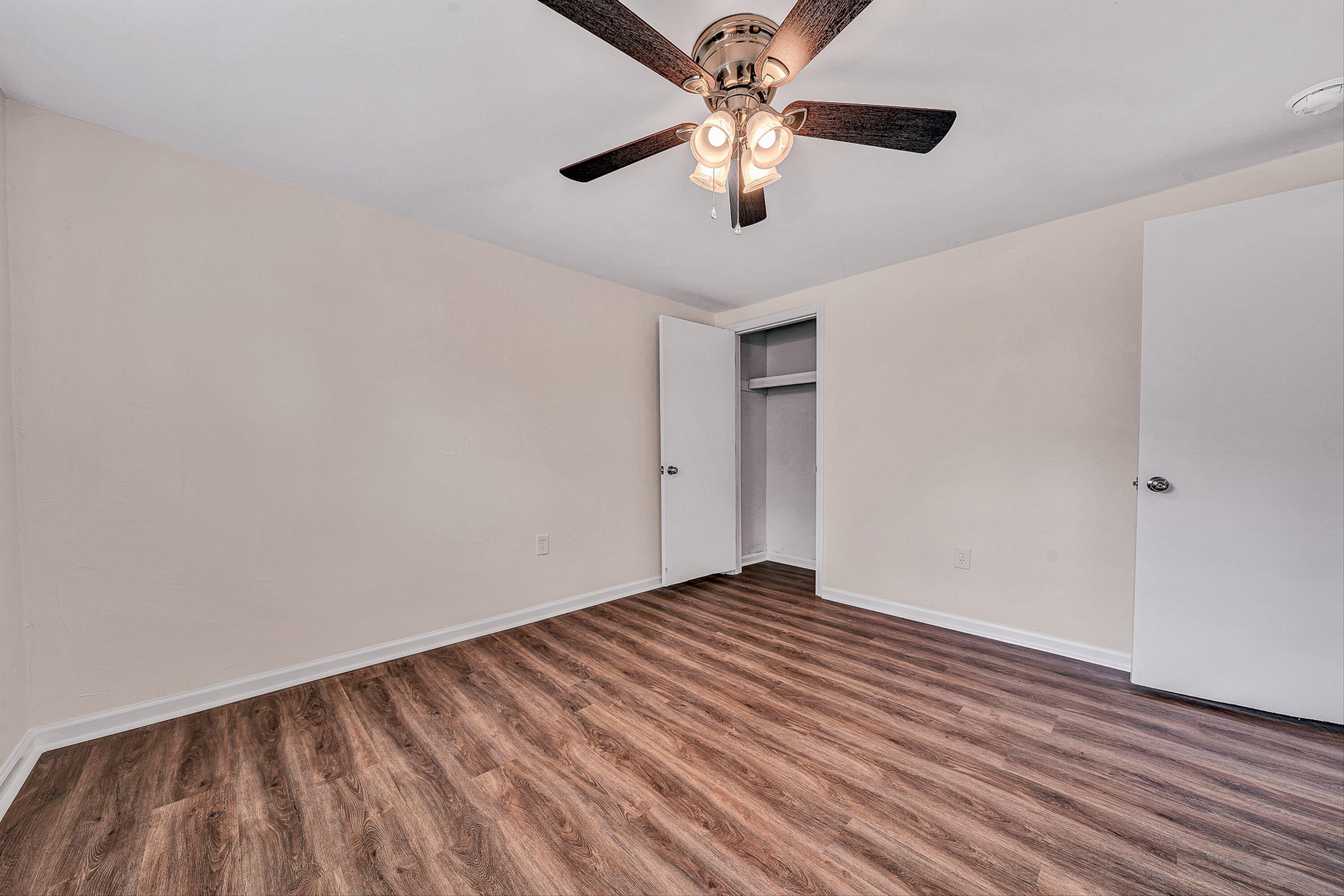 736 Ramada Road Vinton, VA 24179 - Photo 28 of 37 an empty room with wooden floor ceiling fan and windows