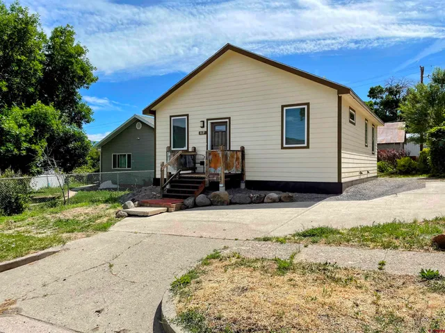 a view of a house with backyard and trees