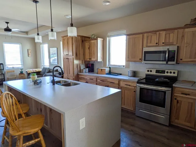 a kitchen with sink a microwave and wooden floor