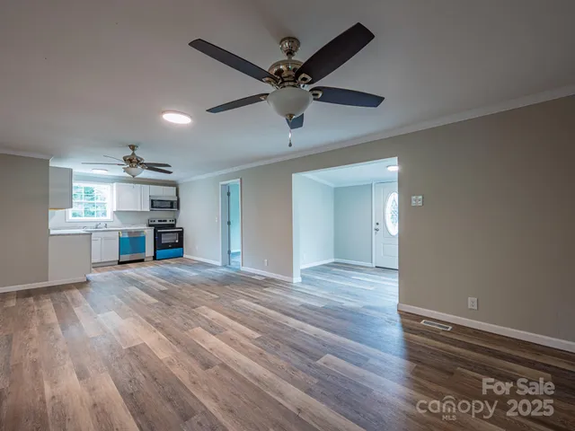 a view of a kitchen with wooden floor and a ceiling fan