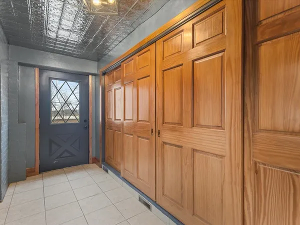 a view of an empty room with wooden floor and a ceiling fan