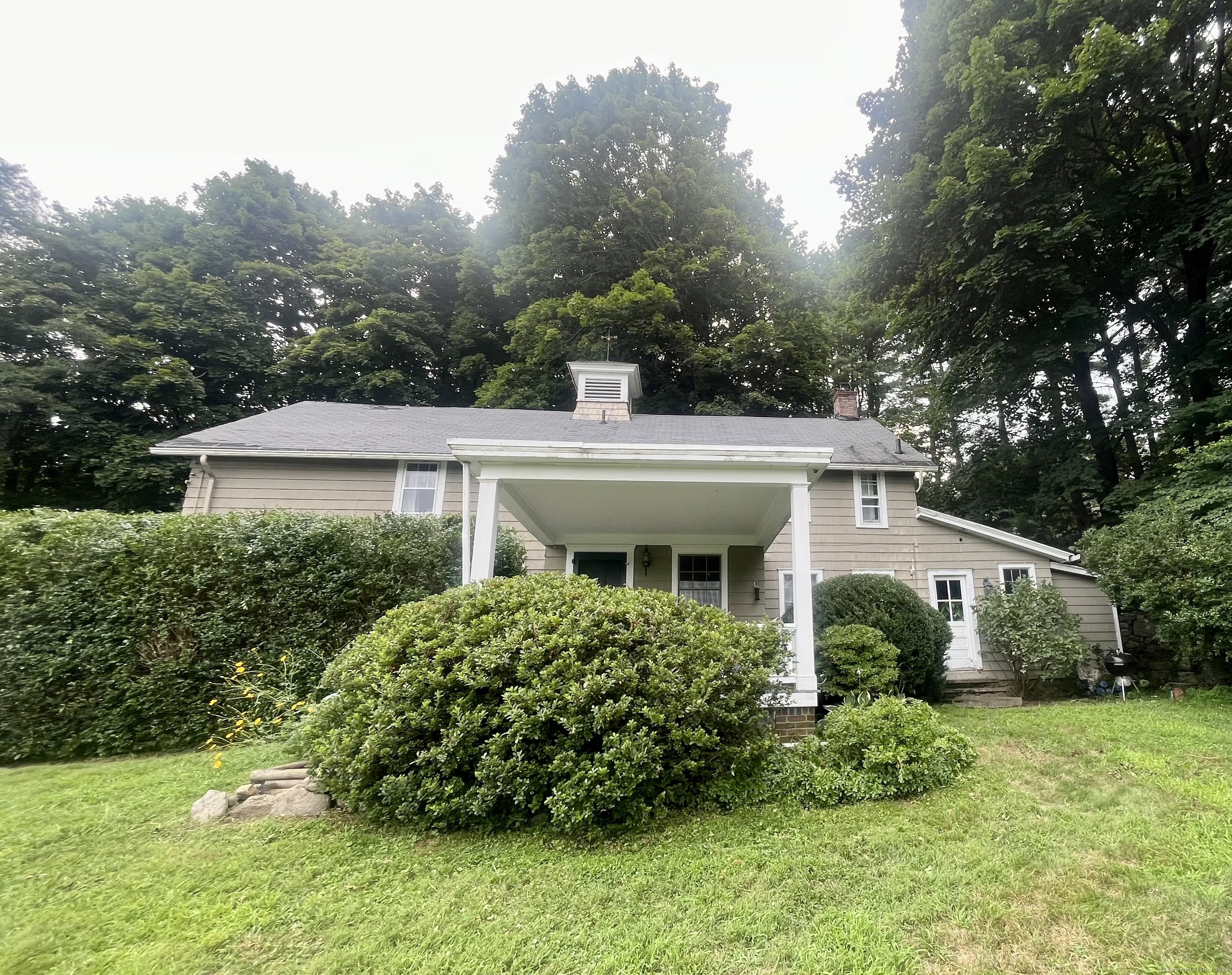 a front view of a house with a garden