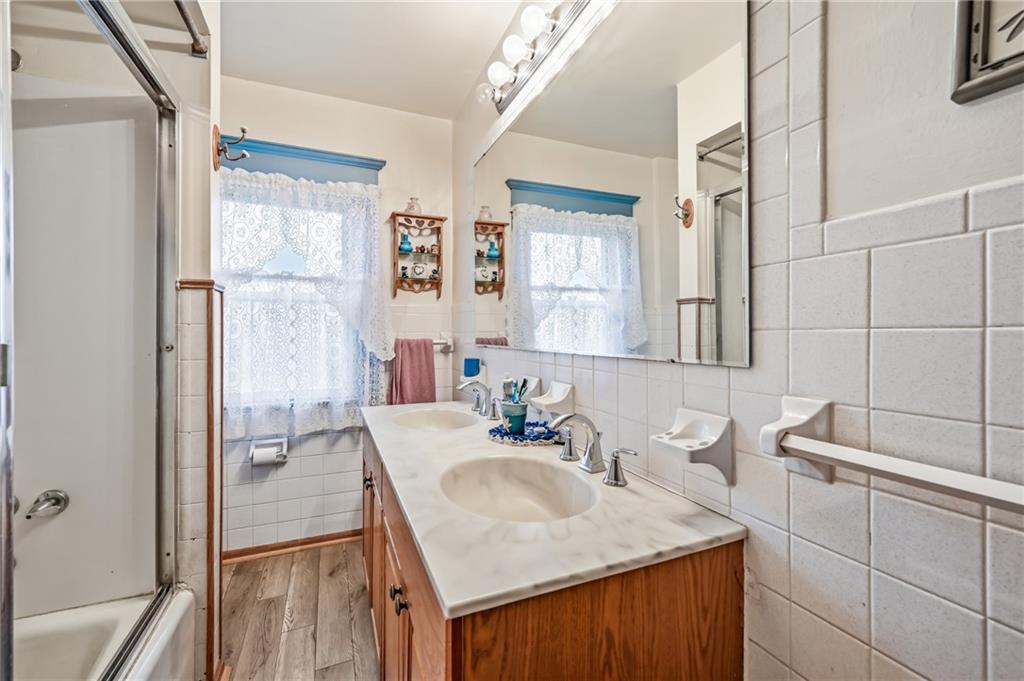 753 Spruce Avenue Sharon, PA 16146 - Photo 21 of 31 a bathroom with a granite countertop sink a mirror and a shower