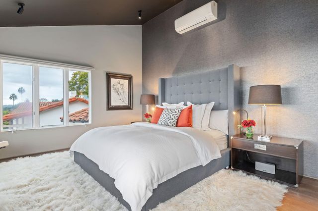 a bedroom with a bed and a lamp on dresser