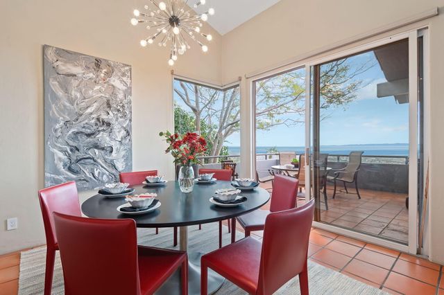 a view of a dining room with furniture large windows and a chandelier