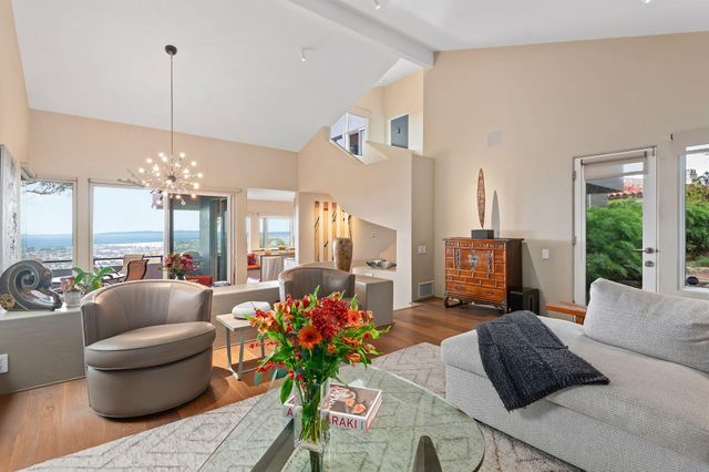 a living room with furniture chandelier and a large window