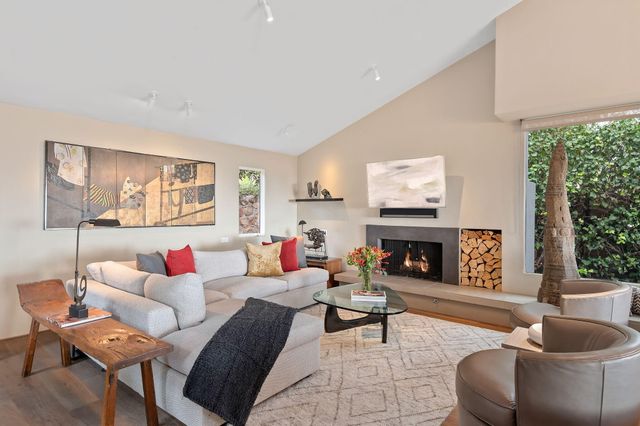 a living room with fireplace furniture and a large window