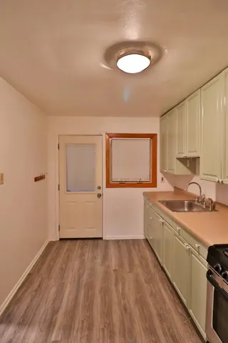 a view of a kitchen with wooden floor and a sink